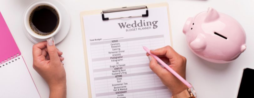 Wedding budget planner with a checklist, coffee, and piggy bank, including Full Service Wedding DJs services.